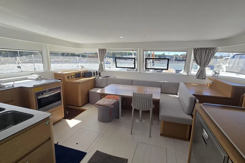  Yacht Photos Pics Modern interior of 2025 Excess 14 catamaran with spacious seating and kitchen area.