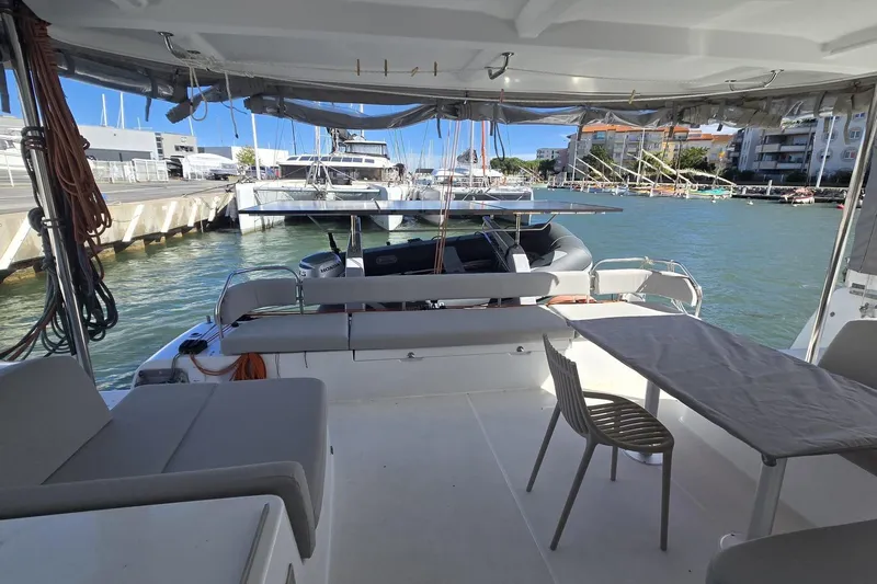  Yacht Photos Pics Modern Excess 14 catamaran interior, 2025 model, docked at a marina with seating and table.