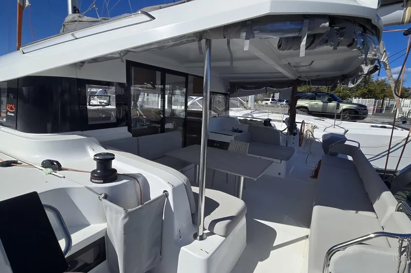  Yacht Photos Pics 2025 Excess 14 catamaran with spacious deck and seating area, docked in marina.