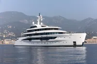 Luxurious 2022 Amels Custom yacht on calm waters with scenic mountain backdrop.