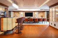 Luxurious dining area on 2022 Amels Custom yacht with elegant bar and seating.