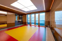 Luxurious Amels Custom 2022 yacht interior with gym, ocean view, and modern design.