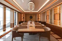 Luxurious dining area on 2022 Amels Custom yacht, featuring elegant decor and modern lighting.