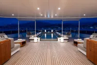 Luxurious 2022 Amels Custom yacht deck with elegant seating and illuminated pool at night.