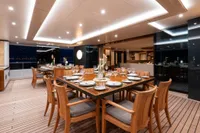 Luxurious dining area on 2022 Amels Custom yacht, featuring elegant table settings and ambient lighting.