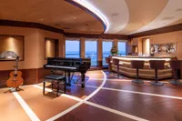 Luxurious yacht interior with grand piano, bar, and ocean view, Amels Custom 2022 model.