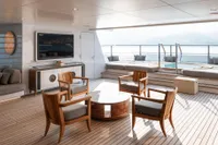 Luxurious 2022 Amels Custom yacht deck with seating, TV, and ocean view.