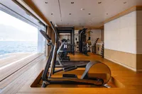 Luxury yacht gym with modern equipment, ocean view, Amels Custom 2022.