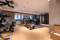 Luxurious gym on 2022 Amels Custom yacht with modern fitness equipment and wooden flooring.