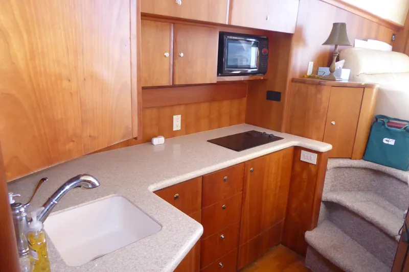 Bee Cee Yacht Photos Pics 2000 Silverton 42C Cummins yacht kitchen with wood cabinets, sink, and microwave.
