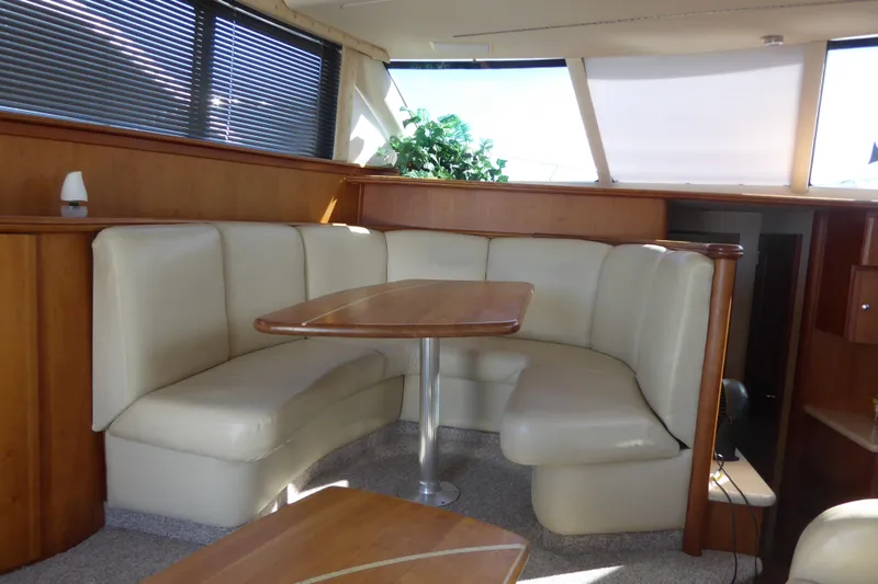 Bee Cee Yacht Photos Pics Luxurious interior of 2000 Silverton 42C yacht with leather seating and wooden table.