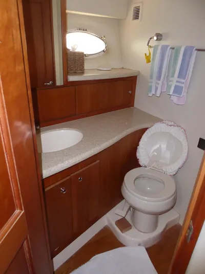 Bee Cee Yacht Photos Pics Luxurious bathroom in 2000 Silverton 42C yacht with wooden cabinetry and modern fixtures.