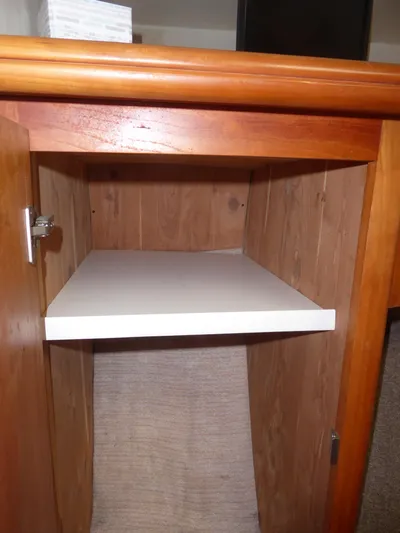 Bee Cee Yacht Photos Pics Wooden cabinet interior with a white shelf, part of a 2000 Silverton 42C Cummins yacht.