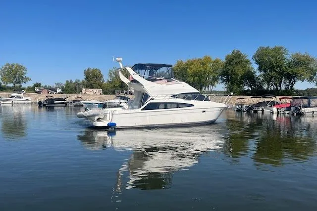  Yacht Photos Pics 2005 Carver 38 Super Sport yacht docked on calm water, surrounded by trees and boats.