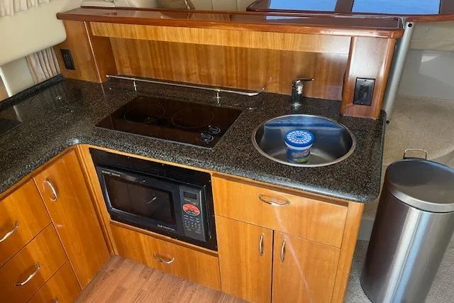  Yacht Photos Pics 2005 Carver 38 Super Sport yacht kitchen with stove, microwave, and sink.