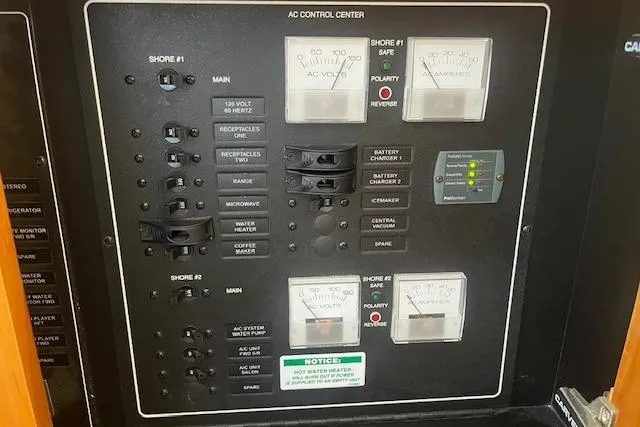  Yacht Photos Pics AC control panel of 2005 Carver 38 Super Sport boat with various switches and meters.