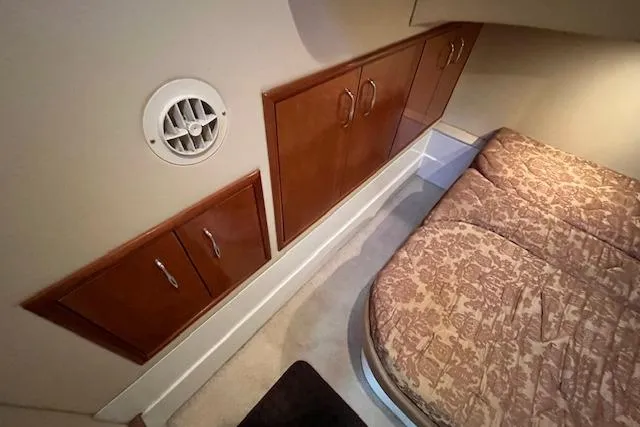  Yacht Photos Pics Interior cabin of 2005 Carver 38 Super Sport with wood cabinets and patterned bedding.