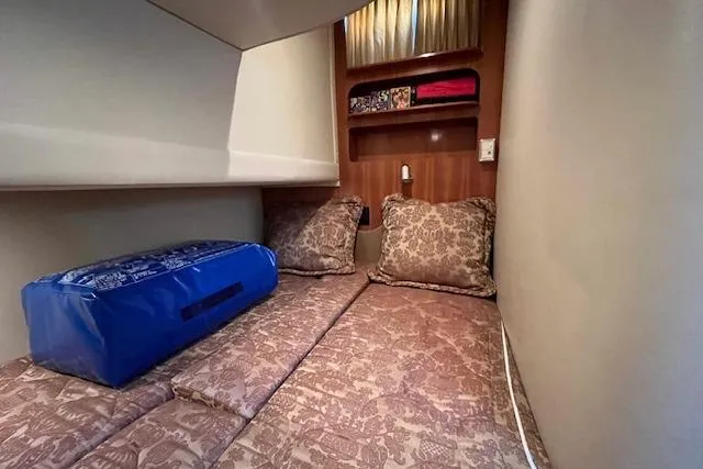  Yacht Photos Pics 2005 Carver 38 Super Sport cabin with cozy bedding and storage shelves.