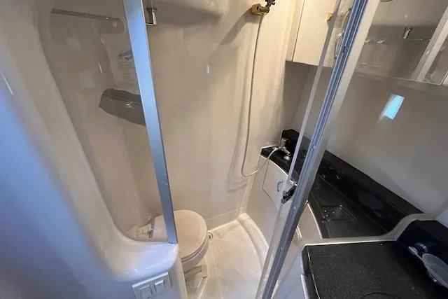  Yacht Photos Pics 2005 Carver 38 Super Sport yacht bathroom with shower, toilet, and sleek black countertop.