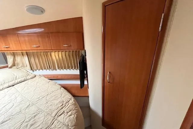  Yacht Photos Pics Interior of 2005 Carver 38 Super Sport yacht with wood cabinetry and cozy bed.