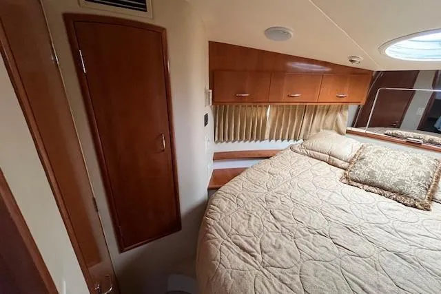  Yacht Photos Pics 2005 Carver 38 Super Sport cabin interior with bed, wooden cabinets, and porthole window.