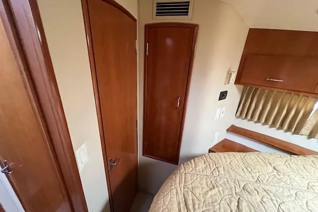  Yacht Photos Pics Interior of 2005 Carver 38 Super Sport yacht with wood paneling and cozy bedroom.