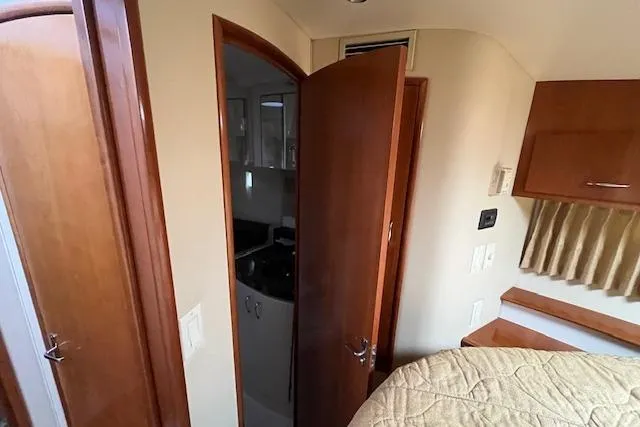  Yacht Photos Pics Interior of 2005 Carver 38 Super Sport yacht, featuring wood paneling and cozy bedroom.