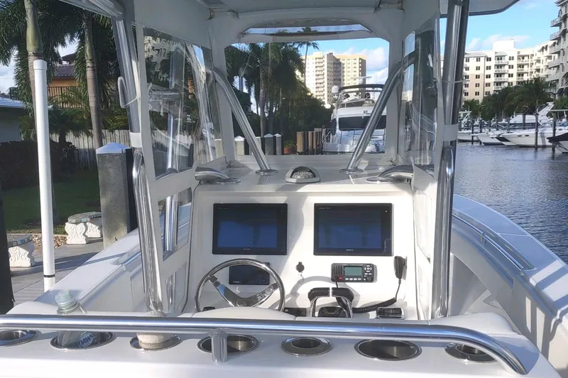  Yacht Photos Pics 2017 Invincible 33 Open Fisherman boat dashboard with dual screens, docked in a marina.