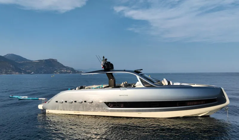  Yacht Photos Pics 2023 Invictus TT460 yacht on calm sea with scenic mountain backdrop.