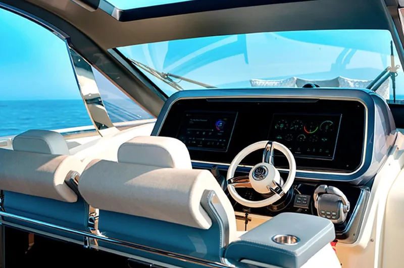  Yacht Photos Pics 2023 Invictus TT460 yacht cockpit with modern steering and digital displays, overlooking the ocean.