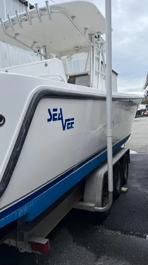  Yacht Photos Pics 2003 SeaVee 34B boat on trailer, white with blue accents, docked outdoors.