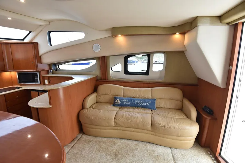 Pura Vida Yacht Photos Pics Luxurious interior of 2010 Silverton 38 Sedan Bridge yacht with leather sofa and modern kitchen.