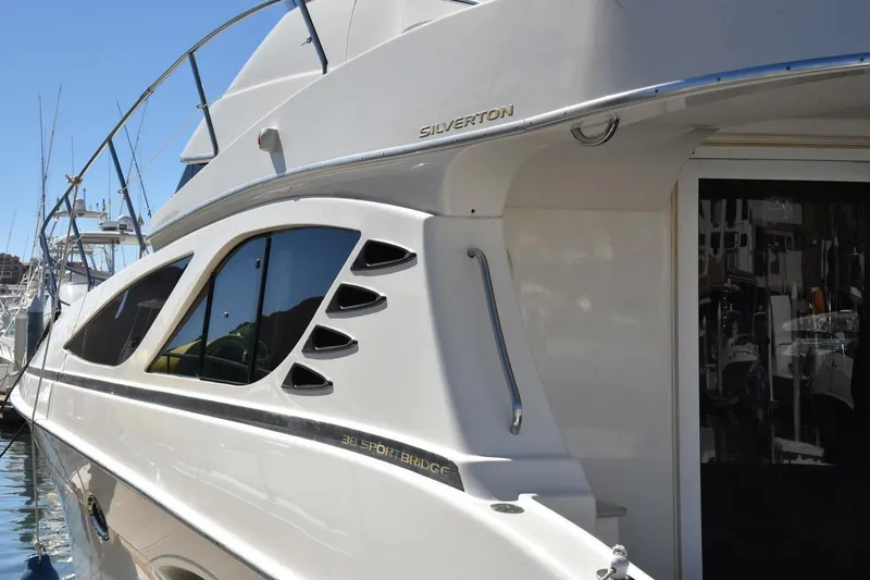 Pura Vida Yacht Photos Pics 2010 Silverton 38 Sedan Bridge yacht docked at marina, showcasing sleek design and windows.