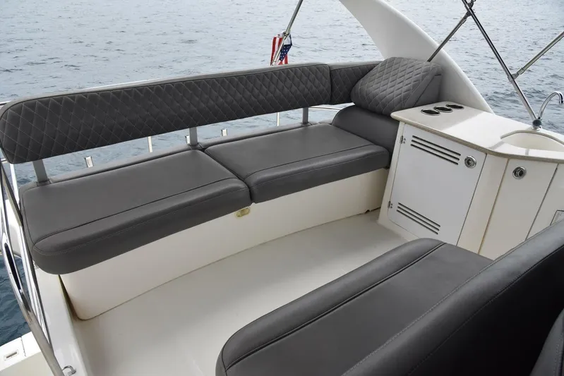 Pura Vida Yacht Photos Pics 2010 Silverton 38 Sedan Bridge interior with gray seating and storage, overlooking the water.