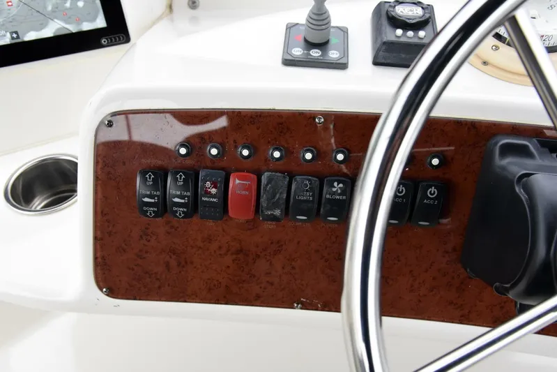 Pura Vida Yacht Photos Pics Control panel of a 2010 Silverton 38 Sedan Bridge boat with switches and steering wheel.