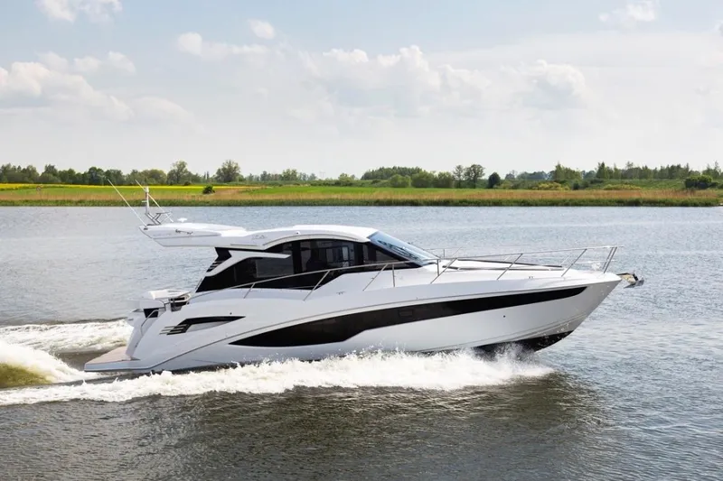  Yacht Photos Pics 2023 Galeon 425 HTS yacht cruising on a serene lake under a clear sky.