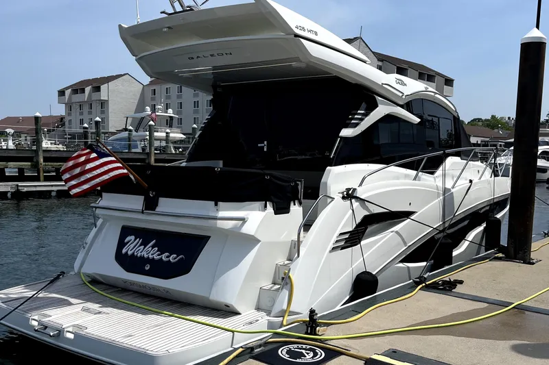  Yacht Photos Pics 2023 Galeon 425 HTS yacht docked with American flag, marina background.