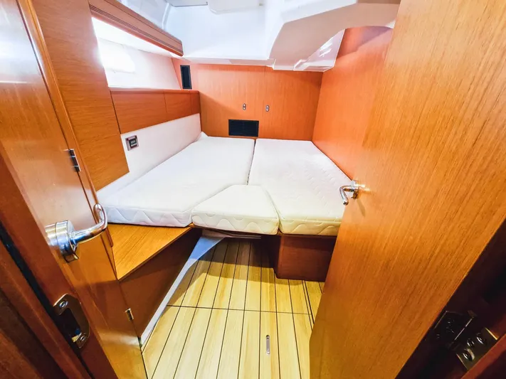  Yacht Photos Pics Cabin interior of 2015 Jeanneau 53 yacht with wooden finish and cozy bed.