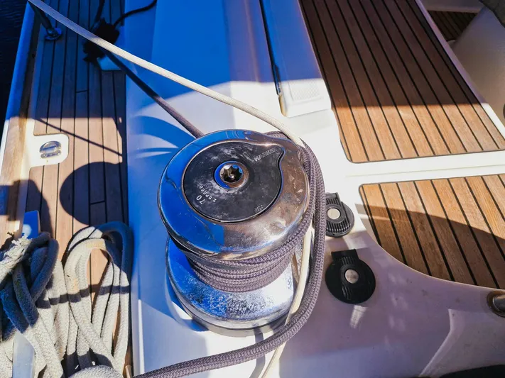  Yacht Photos Pics Winch on Jeanneau 53 sailboat deck, 2015 model, with ropes and wooden flooring.