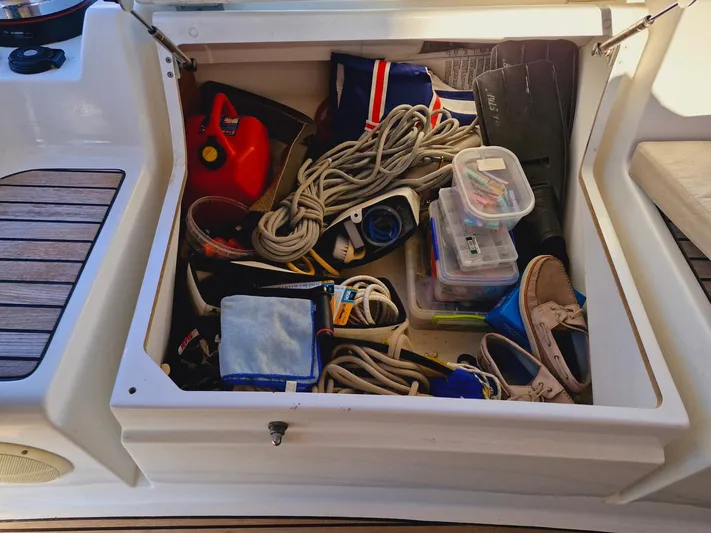  Yacht Photos Pics Storage compartment on a 2015 Jeanneau 53 sailboat filled with ropes, shoes, and gear.