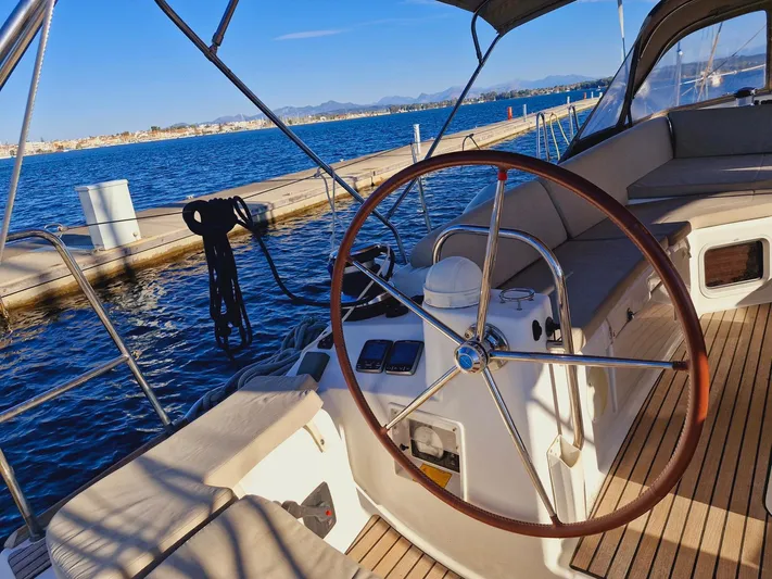  Yacht Photos Pics Jeanneau 53 sailboat cockpit with wooden steering wheel, docked by the water, 2015 model.
