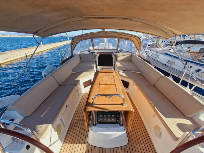  Yacht Photos Pics Spacious cockpit of 2015 Jeanneau 53 yacht with comfortable seating and wooden table.