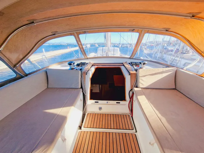  Yacht Photos Pics 2015 Jeanneau 53 yacht cockpit with cushioned seating and wooden flooring.