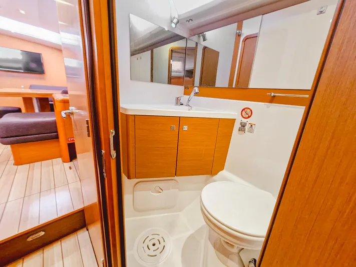  Yacht Photos Pics Luxurious bathroom in a 2015 Jeanneau 53 yacht, featuring modern fixtures and wooden cabinetry.