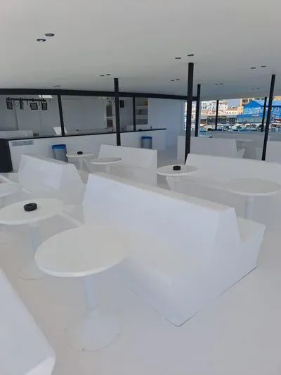 Salone Yacht Photos Pics Modern interior of a 2015 Power Catamaran with white seating and tables.
