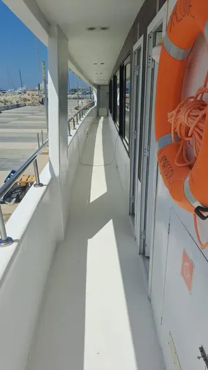 Salone Yacht Photos Pics Side deck of a 2015 Power Catamaran with lifebuoy and marina view.