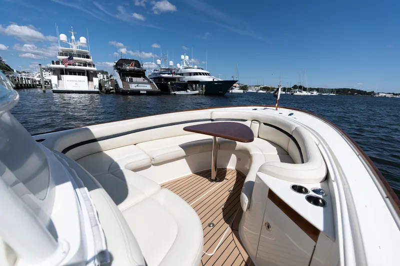 Hunt 32cc-035 Yacht Photos Pics 2019 Hunt Yachts 32CC boat interior with elegant seating and table, docked near luxury yachts.