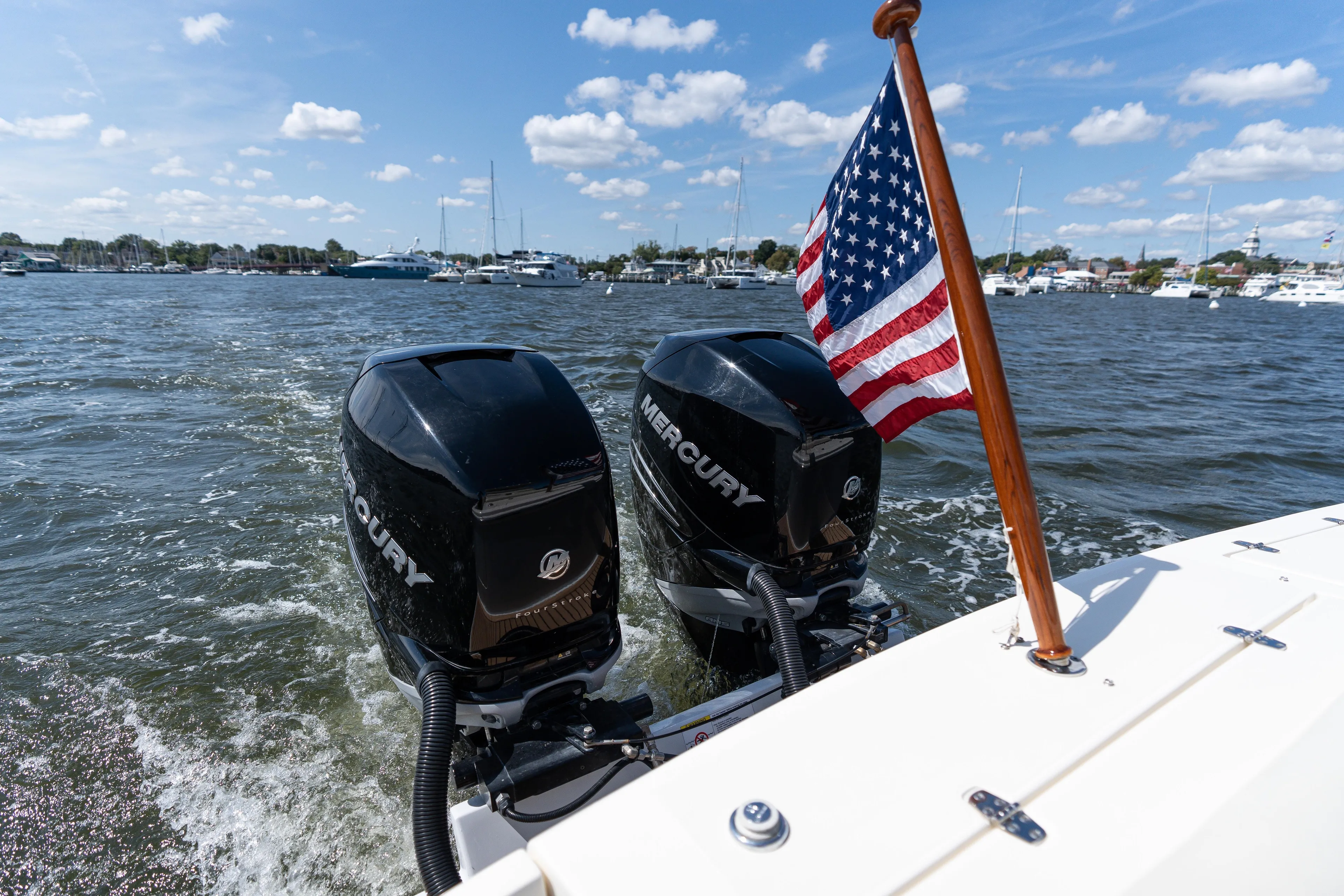 Hunt 32cc-035 Yacht Photos Pics 2019 Hunt Yachts 32CC with dual Mercury engines and American flag on open water.
