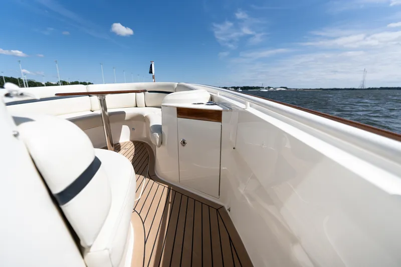 Hunt 32cc-035 Yacht Photos Pics 2019 Hunt Yachts 32CC boat interior with elegant seating and wooden deck, under clear blue sky.