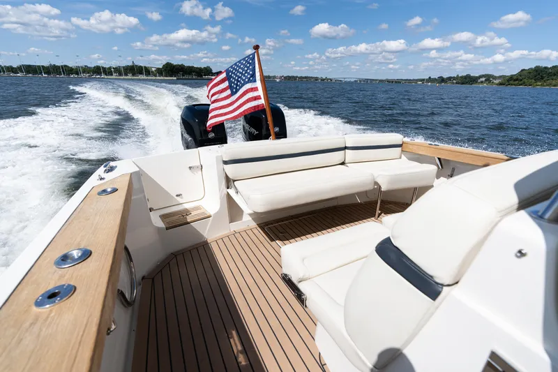 Hunt 32cc-035 Yacht Photos Pics 2019 Hunt Yachts 32CC cruising on water, American flag, sunny day, spacious deck.